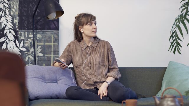 Woman smiling while looking at her mobile at home.